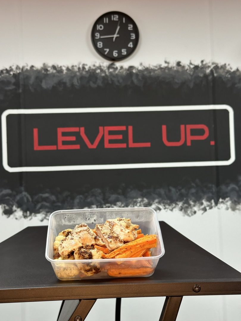 Lemon Honey Mustard Chicken with sweet potato slices, with the level up logo behind the food
